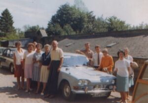 June 1967: The four founders and community members at Donavourd Weavers, Pitlochry. Lena is far right at the front. At the car are, from left: Dorothy, (unknown, unknown), Joannie, Eileen, Peter, Dennis Orme, John and Jan Willoner, Lena, (unknown).